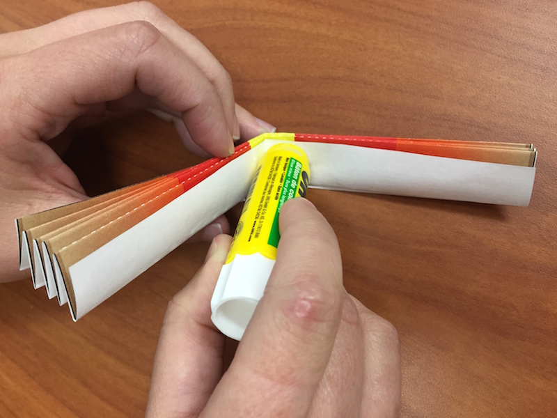 a photo of a glue stick being applied to the inside of the fan fold