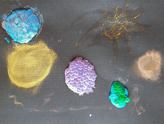 Various planets made out of sequins.