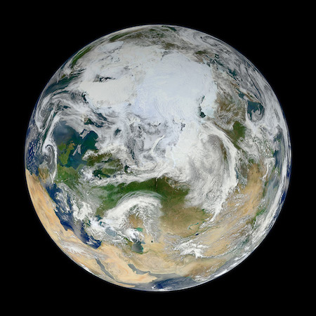 Una foto de la porción norte de la Tierra. Remolinos de blanco lo cubren.