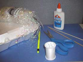Pictures of supplies needed: mylar srips, white glue, thread scissors, wooden skewers, pencil.