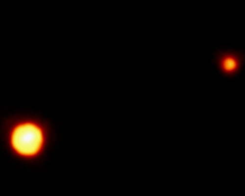 Pluto appears as a bright orange spot in the lower left and Charon as a smaller orange dot in the upper right.