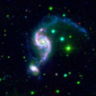 Galaxies interact: These two galaxies—shown in infrared, ultraviolet, and visible light—are so close they distort each other with their gravitational fields. 
