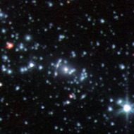Comet Galaxy: It is the bright red object on the left in this Spitzer infrared image. The galaxy is being ripped apart by the gravitational forces at the center of galaxy cluster Abell 2667.