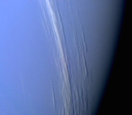 A close up photo of Neptune where it appears a light purple and long white clouds stretch across it.
