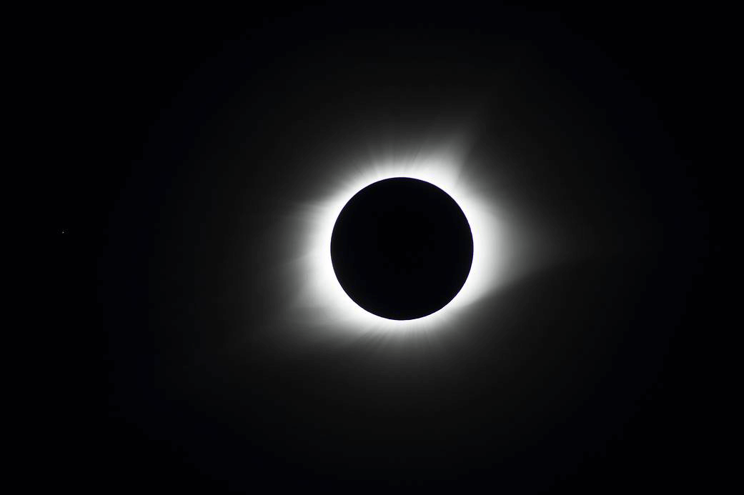 Image of the Moon completely covering the Sun, with just the corona of the Sun visible around the Moon.
