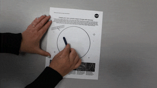 Gif of hand rubbing the side of the blue crayon against the Europa activity page. A faint pattern emerges from the feather underneath the page.