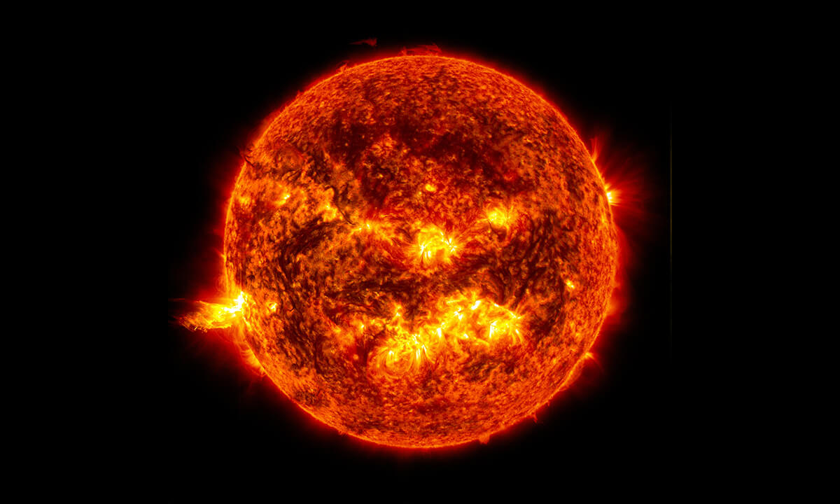 Image shows the bright light of a solar flare on the left side of the Sun.