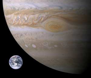 Photographic images of about one-quarter of Jupiter and full Earth side by side, to scale. Earth is tiny.