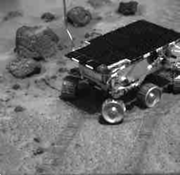 Una película del rover de Sojourner que conduce encima del lado de una roca con un neumático
