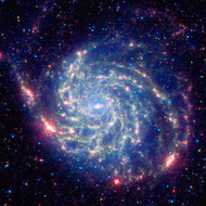 imagen de la galaxia del molinete tomada en infrarrojos para que parezca roja y azul.