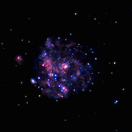 imagen de la galaxia del molinete tomada con rayos X, por lo que la forma del molinete no es visible, sino más bien manchas rosadas y púrpuras.