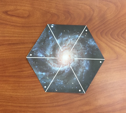 La forma hexagonal recortada de la impresión de la galaxia del molinillo