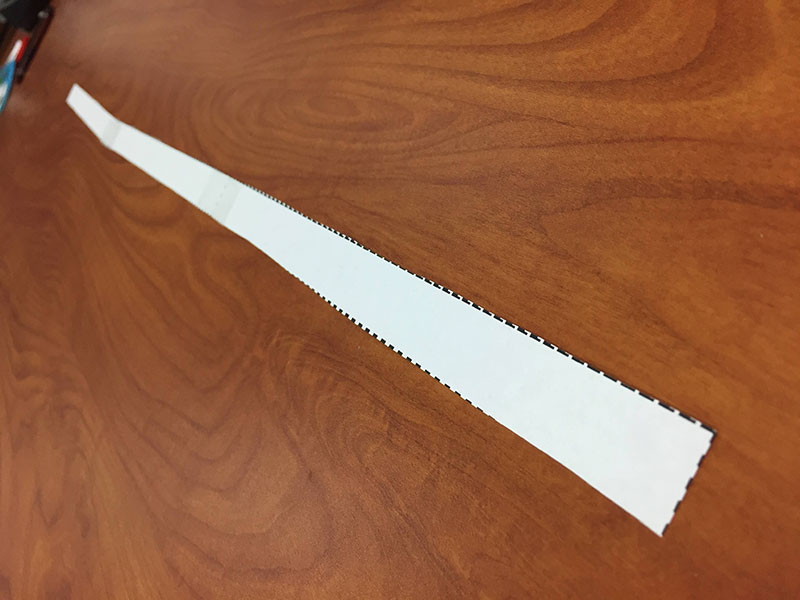 tres tiras de papel, con extremos pegados para crear una tira de papel larga