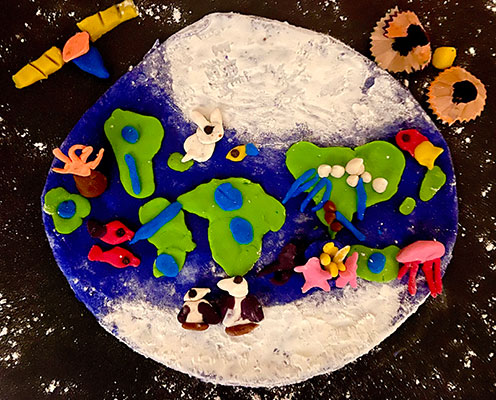 User submitted drawing of the Earth made out of clay with many fish in the ocean areas.