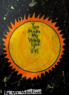 This valentine says, You make my world light up! Be my Valentines. In the center of the image is a bright yellow sun. Bright orange, spiky rays surround the circular yellow sun. The rest of the artwork is black, speckled with yellow paint splatters.