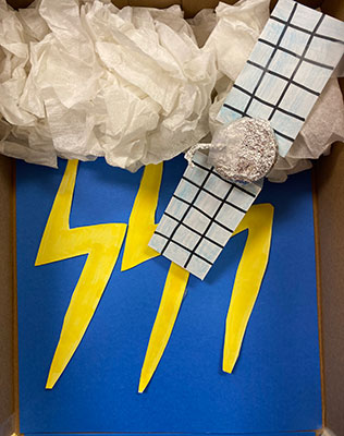 Paper cutouts of lightning, clouds and a spacecraft.