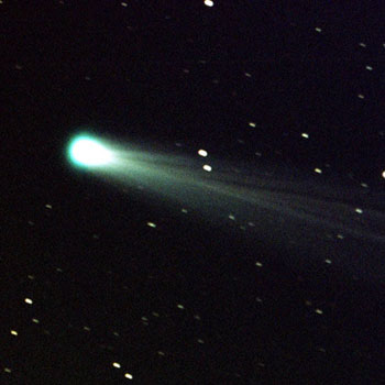 A comet with a long tail in the darkness of space.