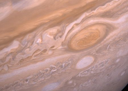 A close up image of Jupiter's Red Spot, showing swirls of brown and red gas.