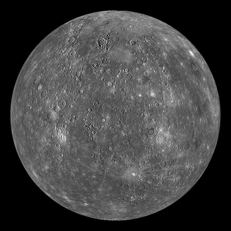 Una foto de un lado iluminado de Mercurio. Tiene cráteres y manchas de colores claros.