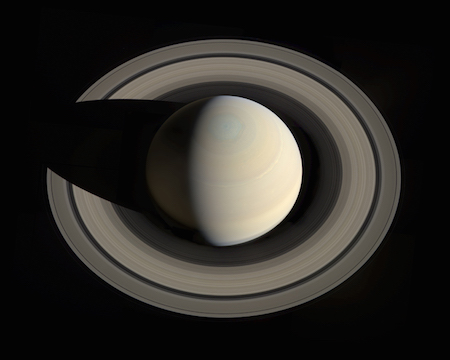 A photo of Saturn looking down on it, showing its rings clearly. The shadow of Saturn falls on the left side of the rings.
