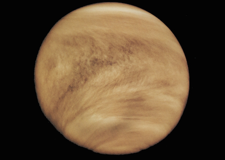una foto de la atmósfera en espiral de nubes marrones rojizas de Venus.