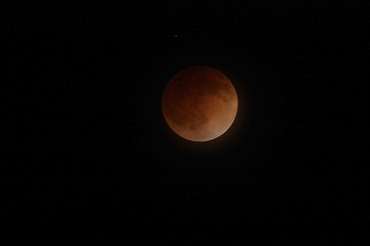 A blood moon against the night sky.