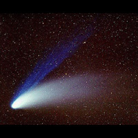 Comet Hale-Bopp nucleus is bright area, with blue ion tail above white dust tail following off to the right.