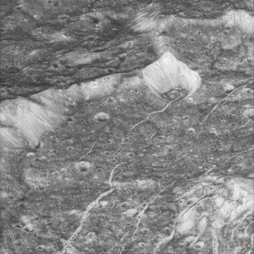 Crestas altas, cráteres y grietas muestran en este primer plano de Dione.