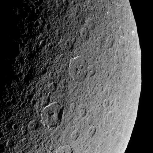 Rhea is bright white and cratered in this image, with slight hints of blue.