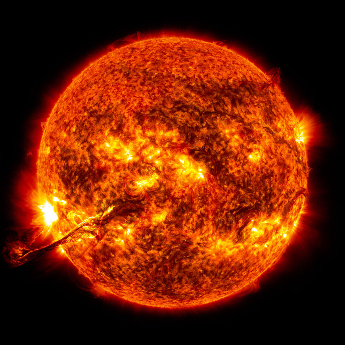 Imagen del Sol con un objeto similar a un dedo en la parte inferior izquierda. Esta es una eyección de masa coronal.