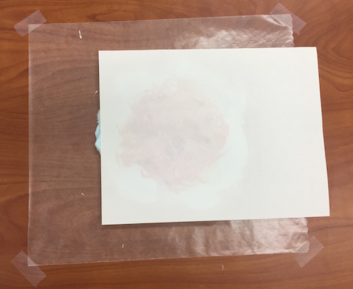 a photo of a piece of paper laid on top of the shaving cream and food coloring