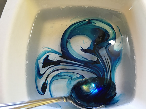 remolinos de colorante azul en la mezcla de agua y pegamento.